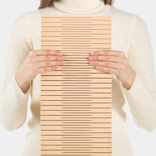 maple-sample-panels-acoustic-panels Una donna che tiene un campione di acero progettato come pannelli acustici