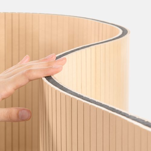 oak-room-divider-acoustic Una mano che tocca un divisorio per ambienti in rovere con design acustico