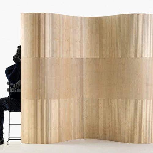 oak-room-divider-wood Un uomo seduto dietro a un divisorio per ambienti in legno di rovere